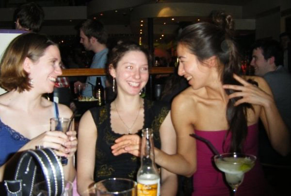 Maria, Rebecca, and another friend at a bar, laughing.